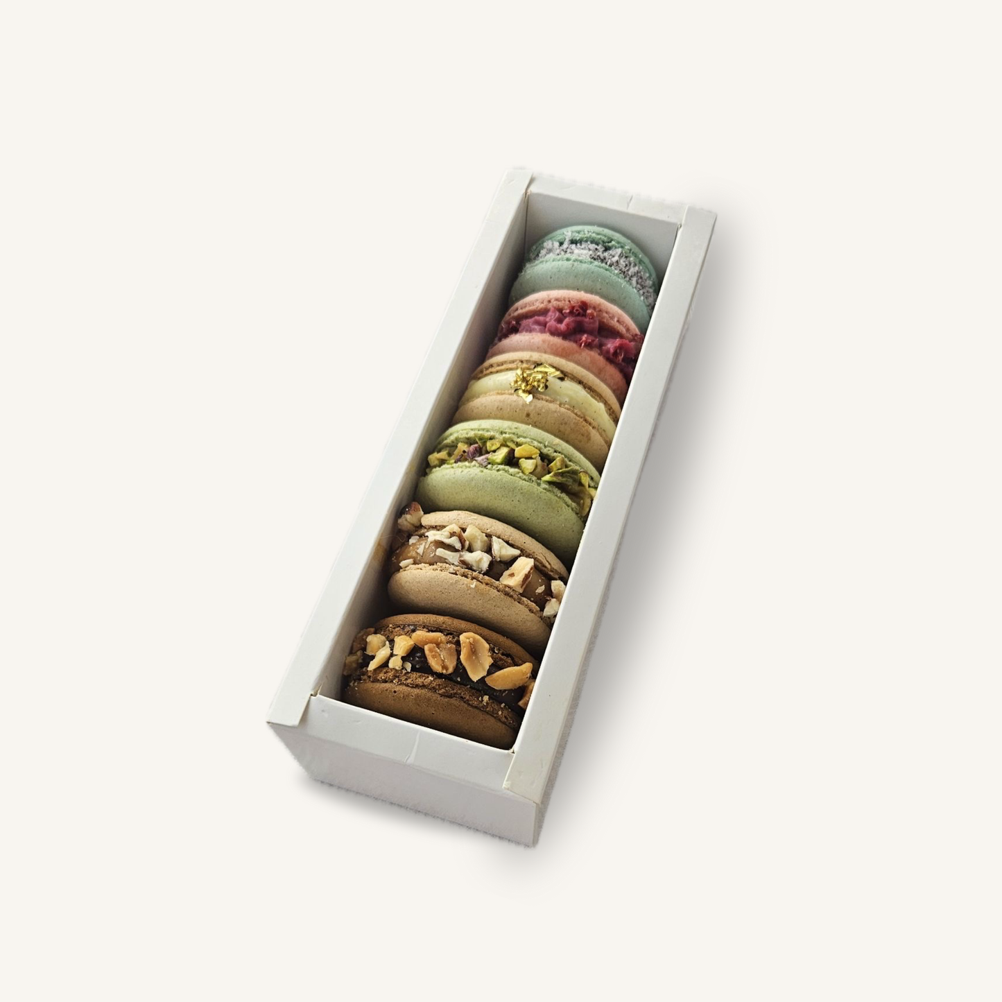Box de six macarons artisanaux assortis, avec parfums personnalisables selon la sélection du client, présentés dans un écrin élégant