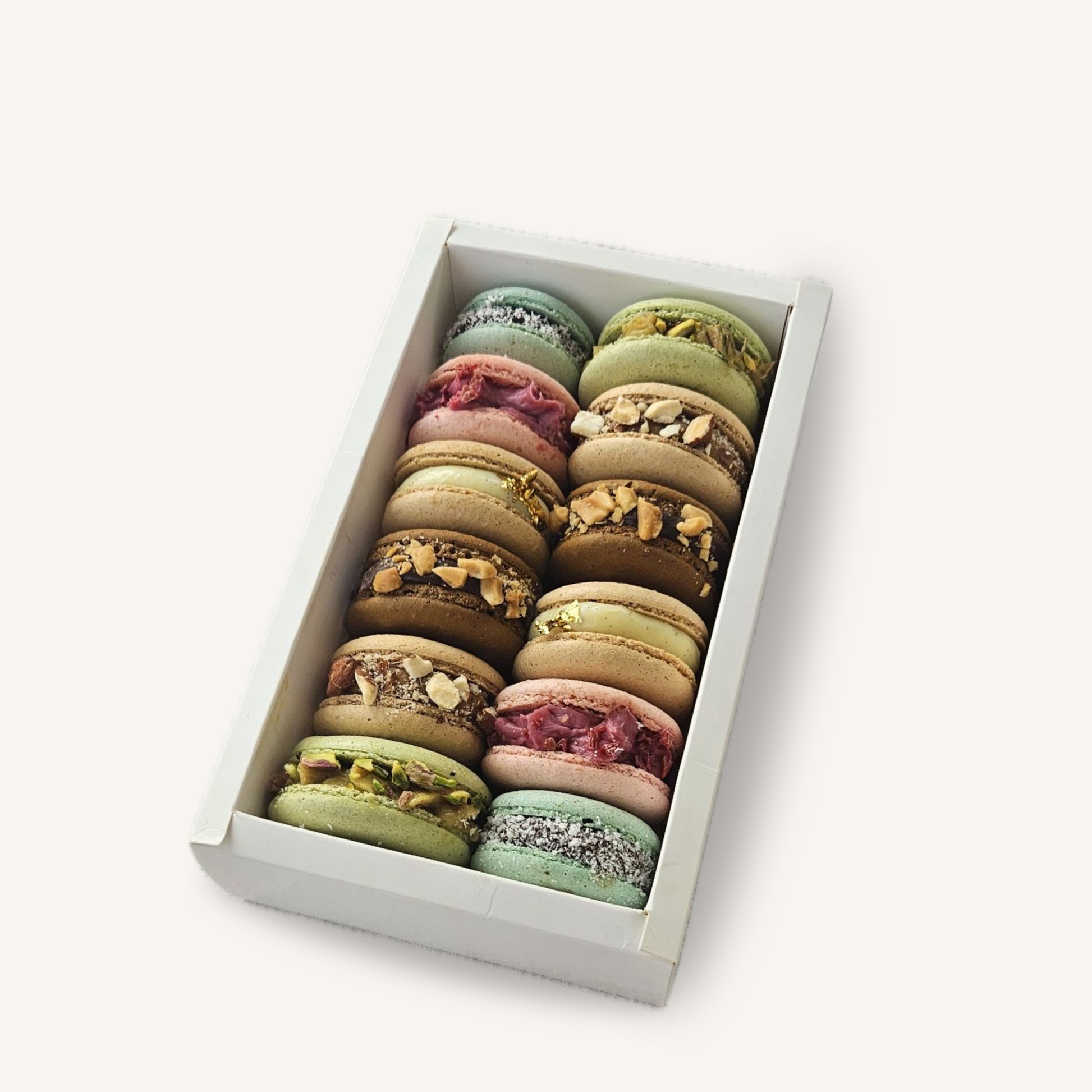 Box de douze macarons artisanaux assortis, avec parfums personnalisables selon la sélection du client, présentés dans un écrin élégant